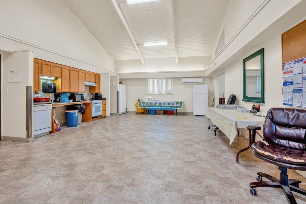 a living room with a kitchen and a table and chairs