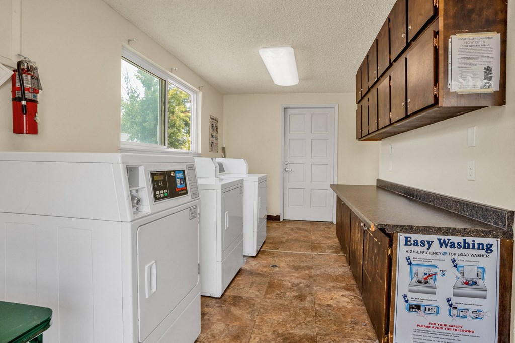 the laundry room is equipped with washer and dryers and has a counter top