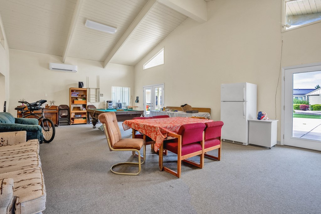 a large living room with a table and chairs