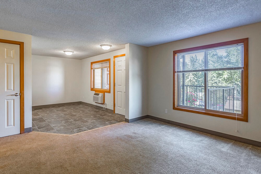 a empty living room with a window and a door