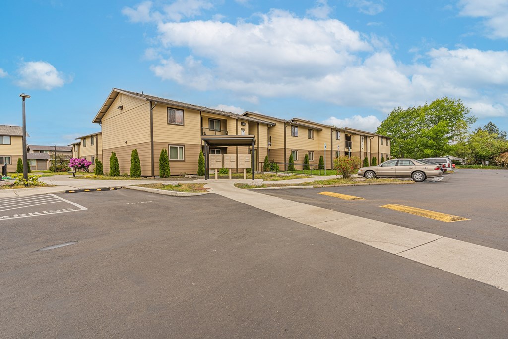 an empty parking lot in front of an apartment building