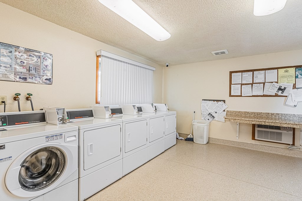 the laundry room is equipped with washers and dryers and has a counter top