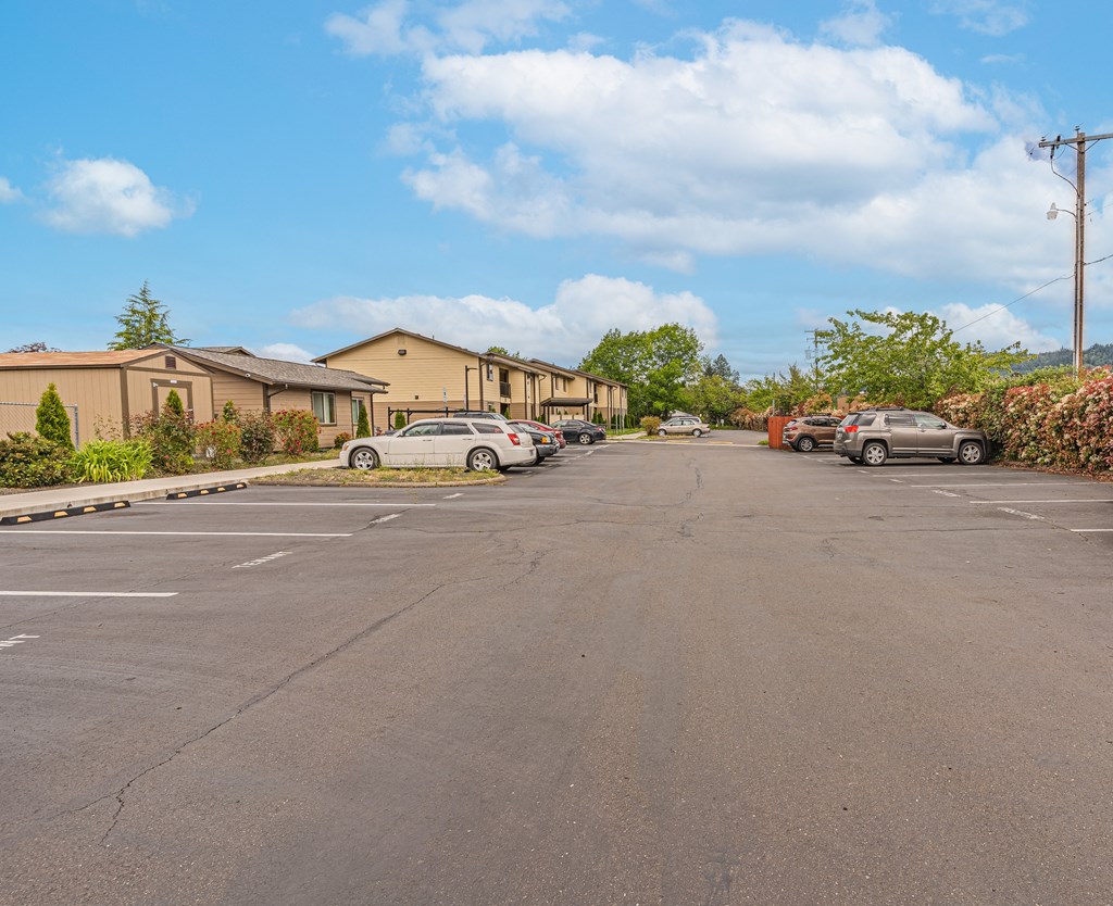 a parking lot with cars parked on the side of a building