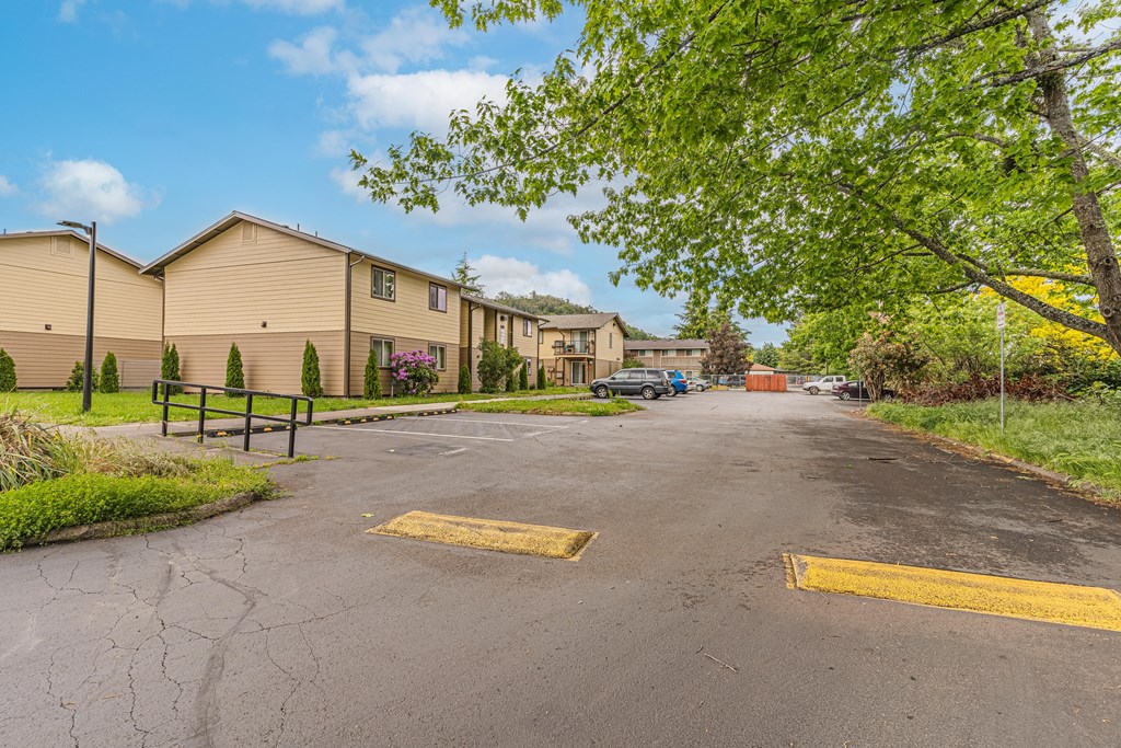 a parking lot with houses on the side of it