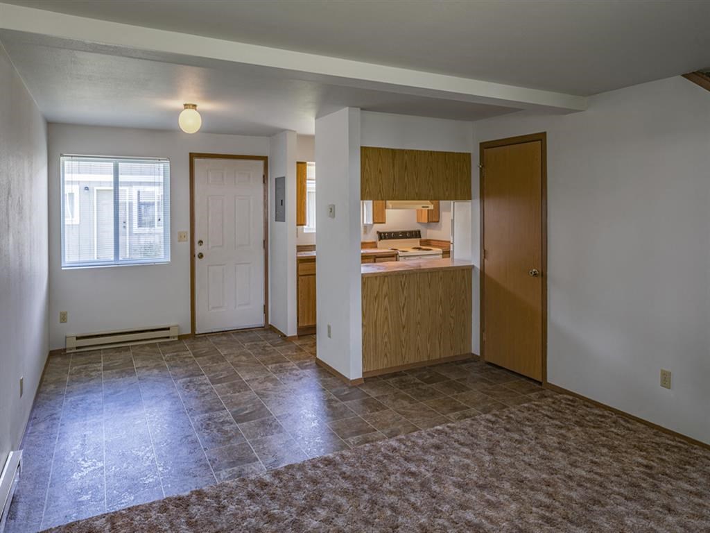 a kitchen and a living room with an empty floor