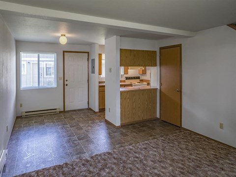 a kitchen and a living room with an empty floor