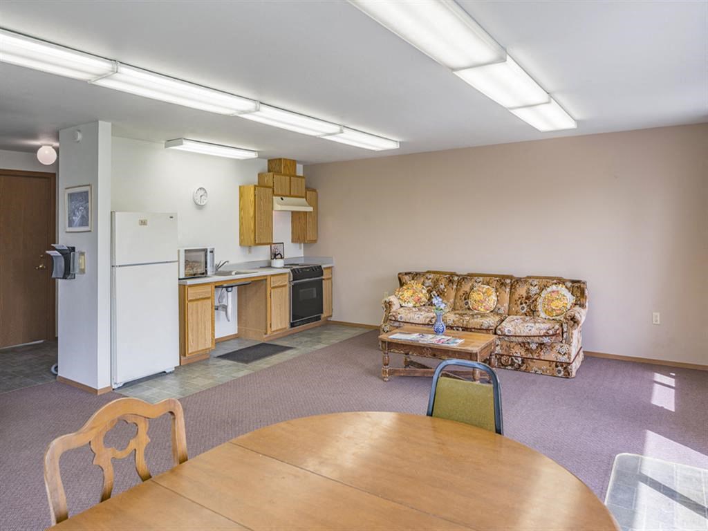 a living room with a kitchen and a table