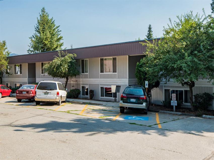 a parking lot with cars in front of a building