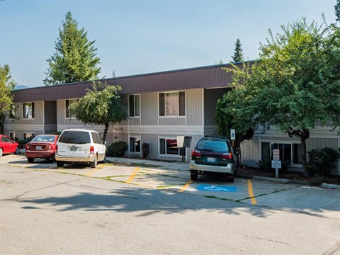 a parking lot with cars in front of a building