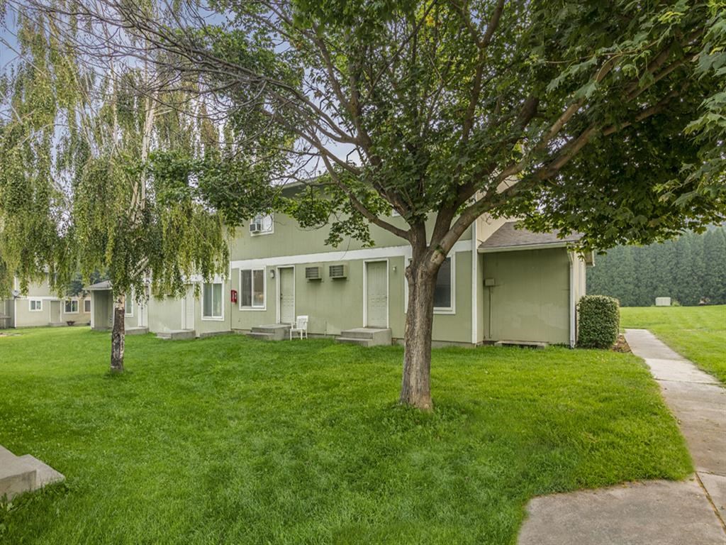 a house with a lawn and trees in front of it