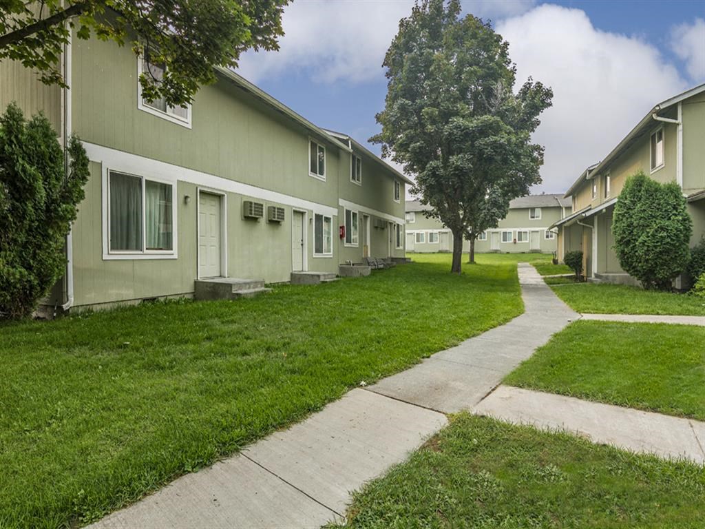 a row of houses on the side of a sidewalk