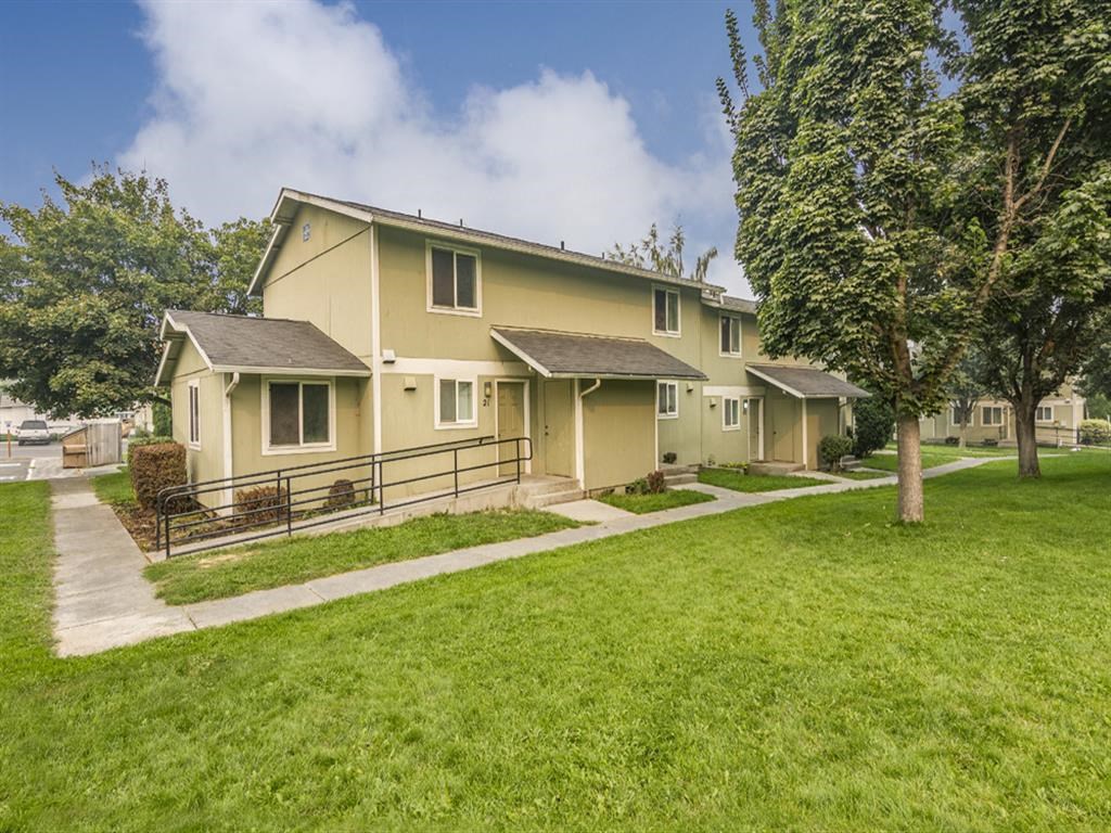 a yellow house with a yard and trees