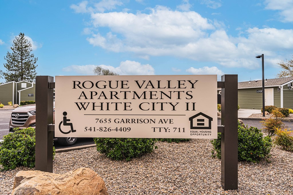 A sign for Rogue Valley Apartments in White City II with a phone number and TTY number.