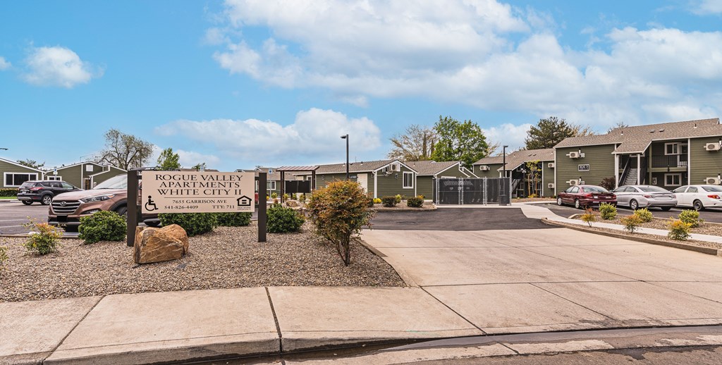 A sign in front of a parking lot reads "Rogue Valley White City.".