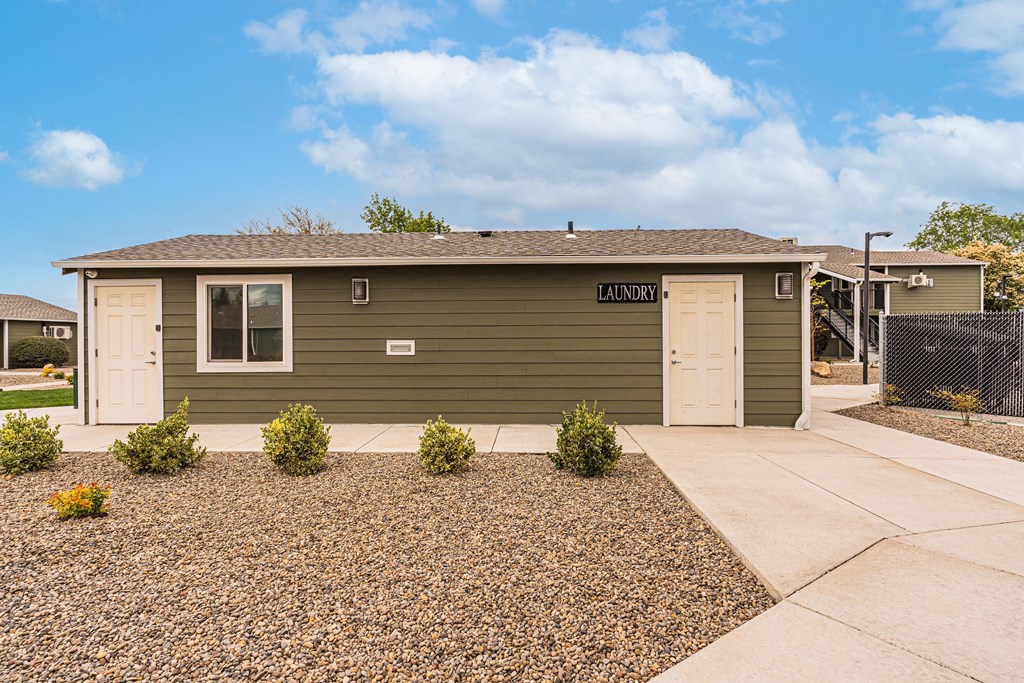 A green building with a laundry sign on it.