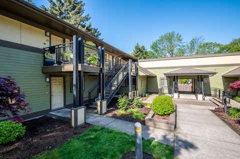 A sunny day at a residential building with a green lawn and a clear blue sky.