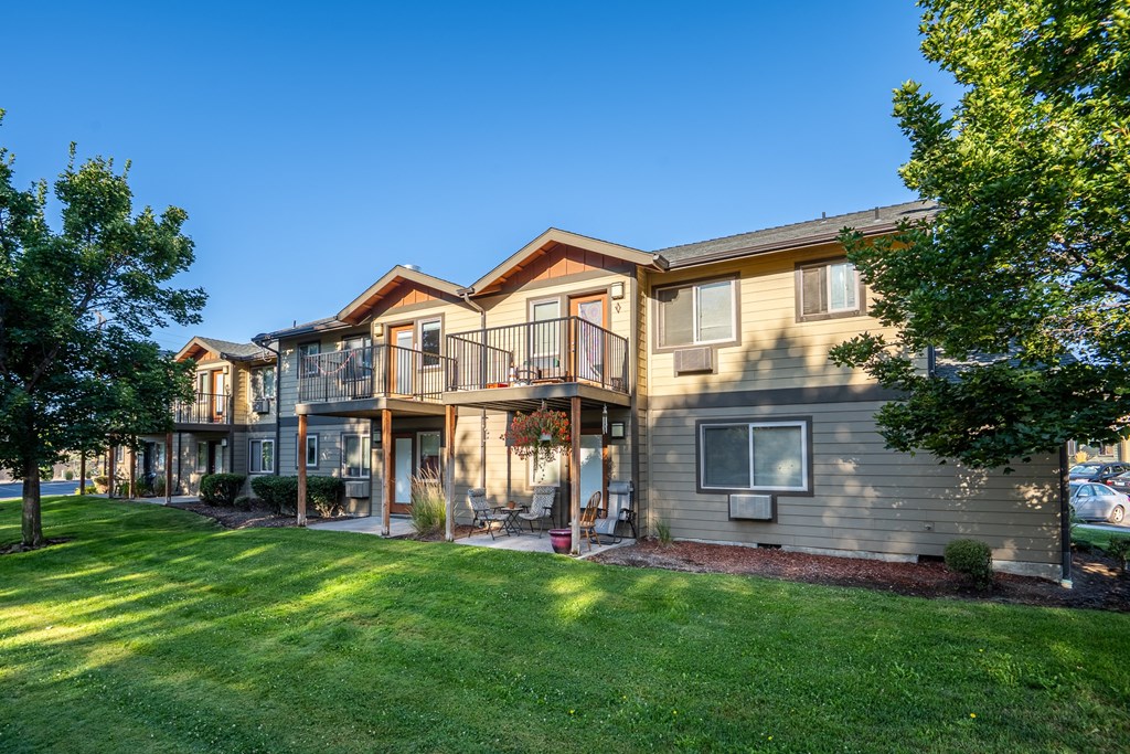 A large house with a balcony and a green lawn in front.