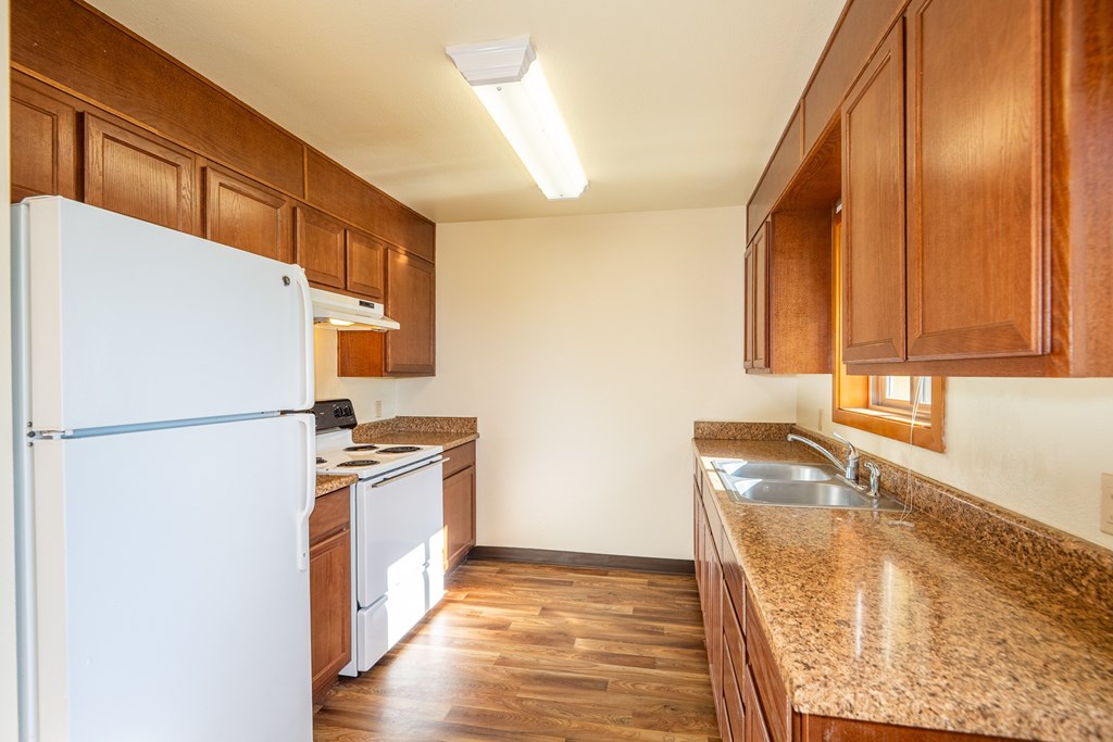 A kitchen with wooden cabinets and a white refrigerator.