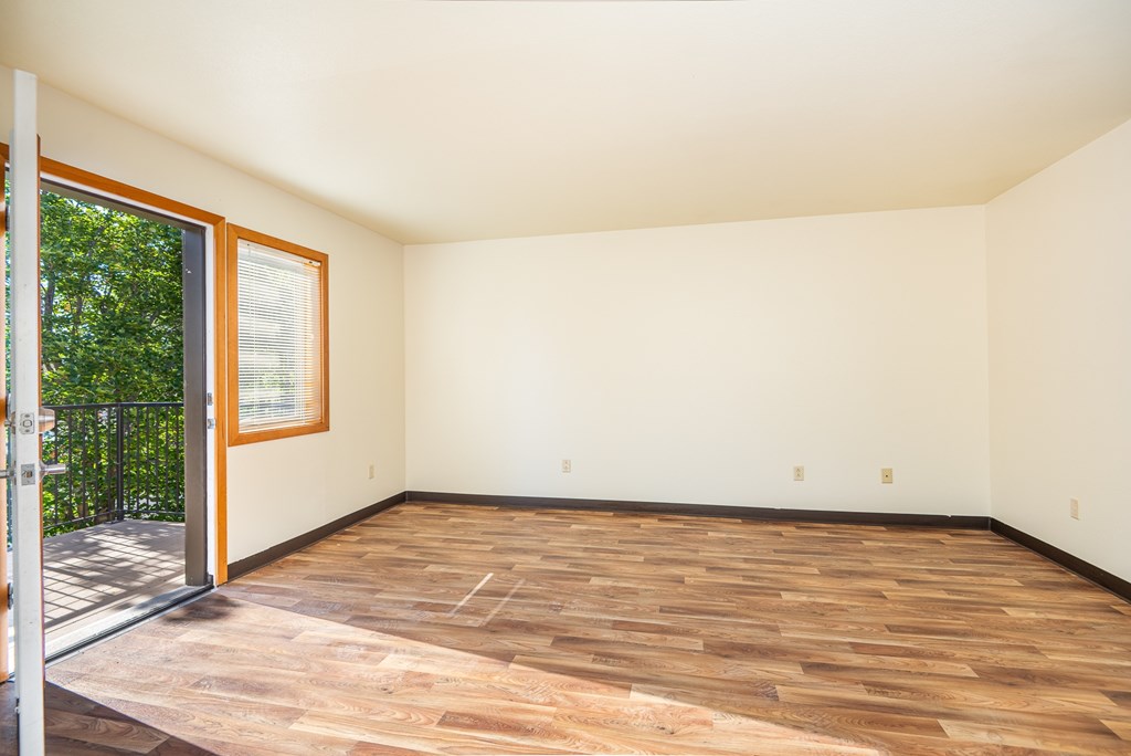 A room with wooden flooring and a sliding glass door.