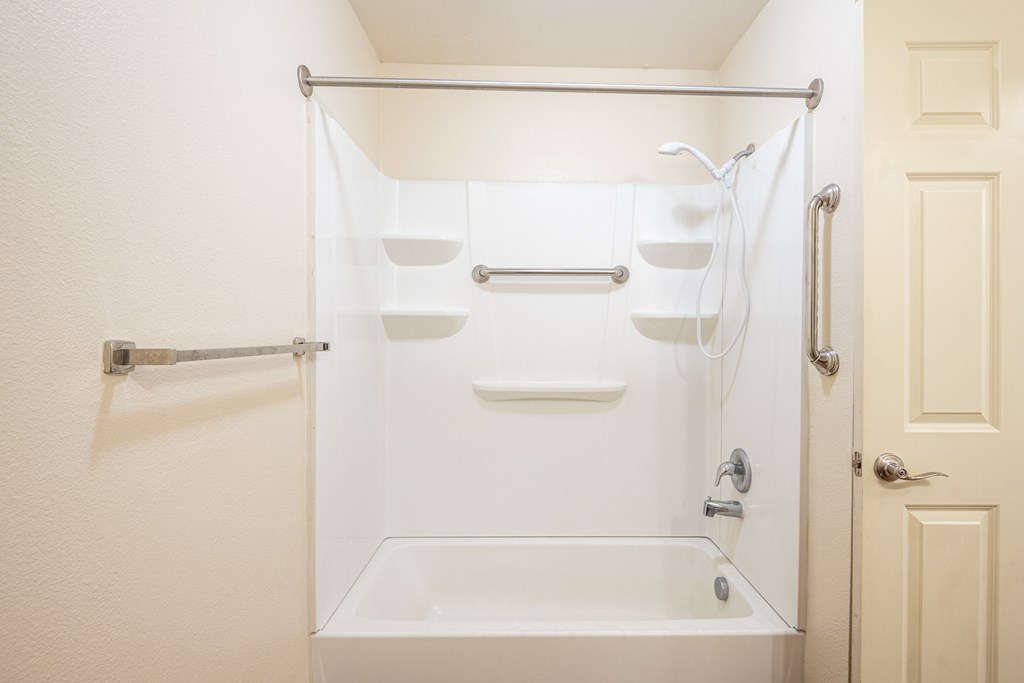 A white bathroom with a shower curtain and a white tub.