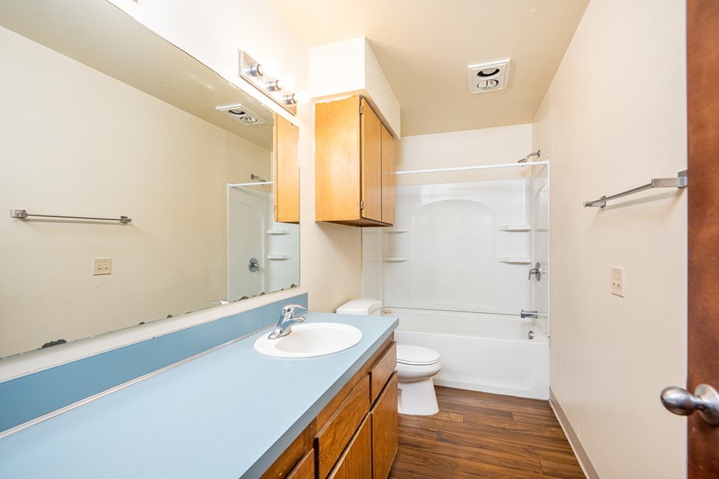 A bathroom with a sink, toilet, and bathtub.