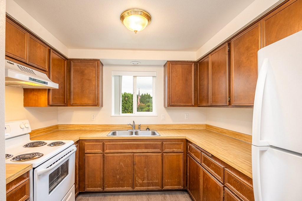 a kitchen with wooden cabinets and white appliances