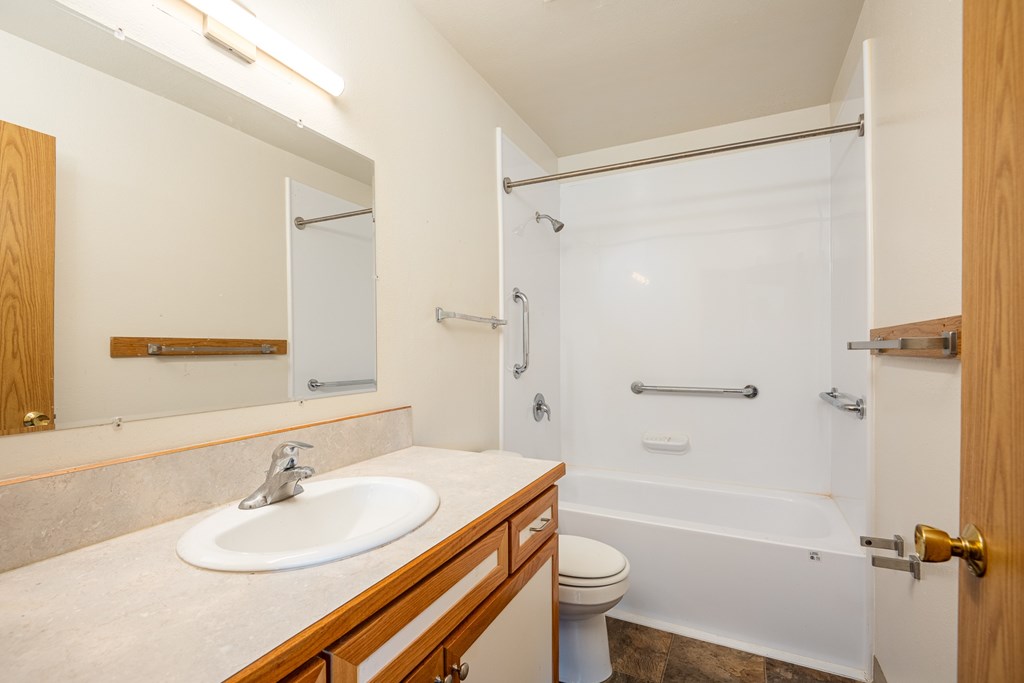 A bathroom with a sink, toilet, and bathtub.