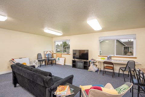 a living room with a couch and a table with chairs and a television