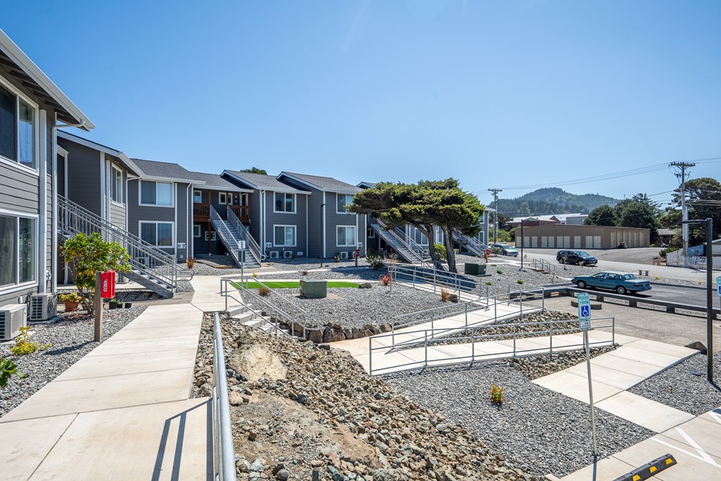 A sunny day at a residential area with apartment buildings and a landscaped garden.