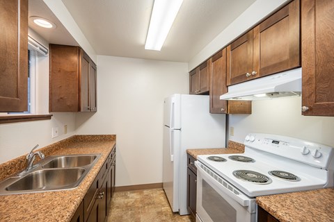 A kitchen with a white refrigerator and a white stove top oven.