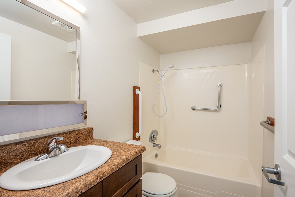 A bathroom with a sink, toilet, and bathtub.