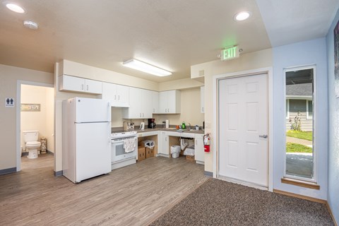 A kitchen with a white fridge and a white door.