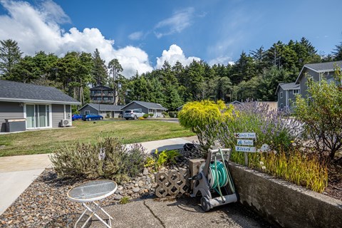 A backyard with a table and chairs and a hose reel.