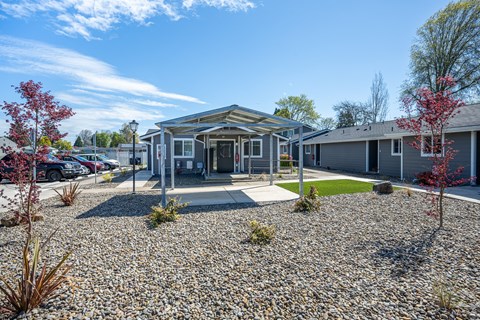A building with a gravel driveway in front of it.