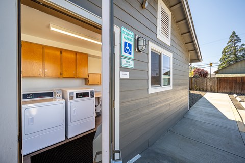 A laundry room with a washer and dryer and a sign that says "RESERVED PARKING".