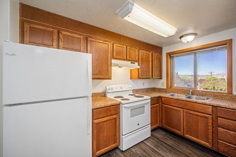 A kitchen with wooden cabinets and a white fridge.