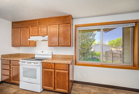 A kitchen with wooden cabinets and a white oven.