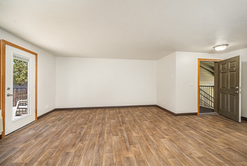 A room with wooden flooring and white walls.