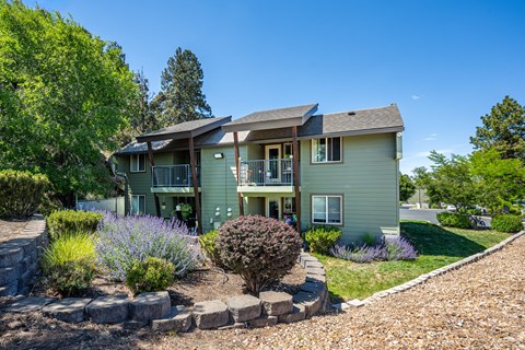 A house with a green exterior and a stone pathway leading to the front door.