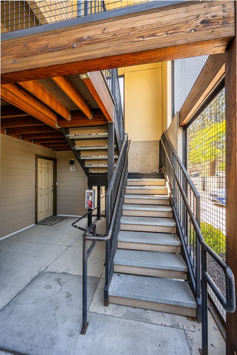 A staircase with a metal railing and wooden handrails.