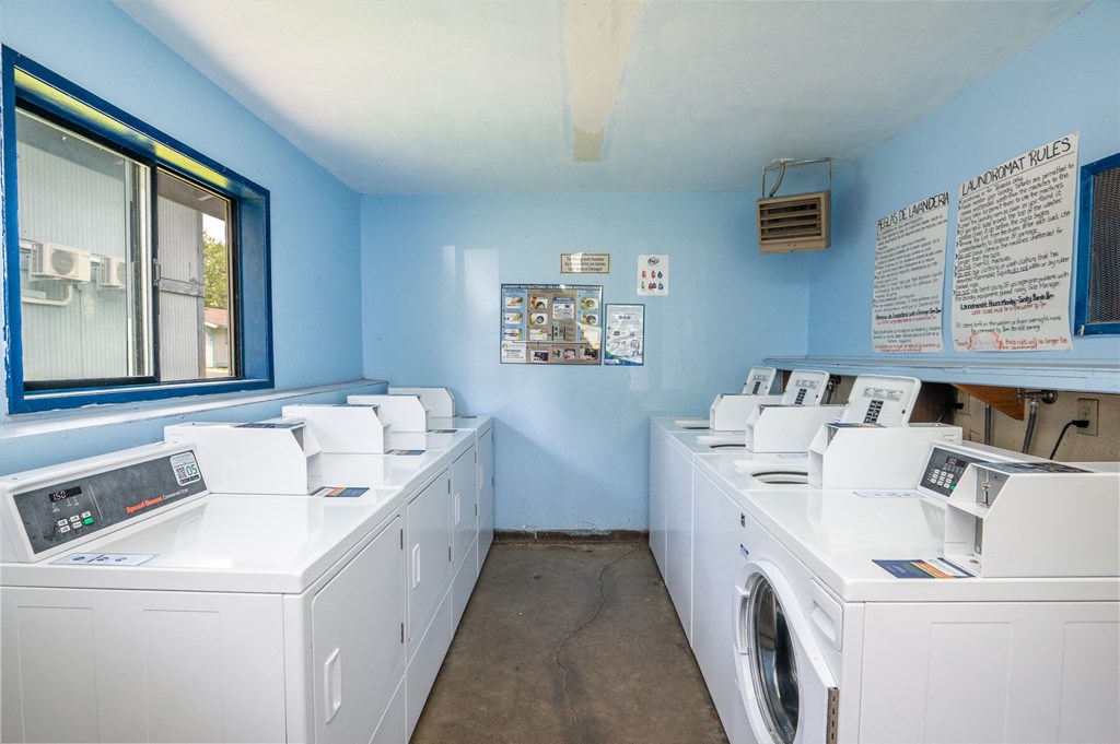 a laundry room with washes and dryers and a window