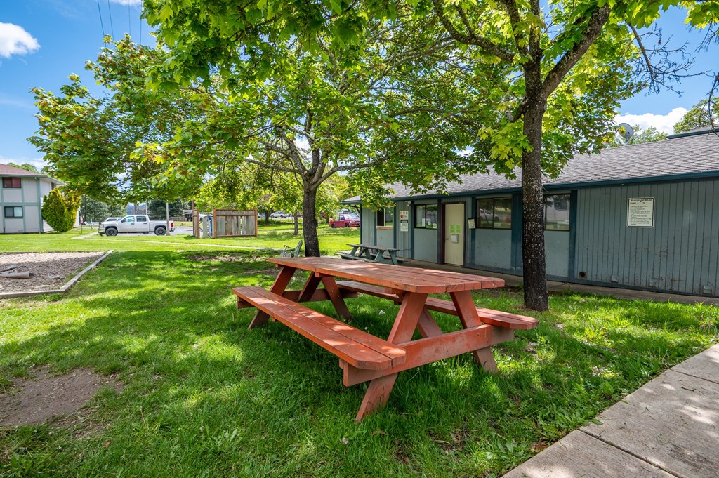 a picnic table on the grass in front of a building