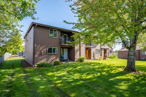 the front of a house with a yard and trees
