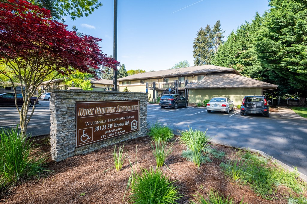 a building with a sign and cars parked in front of it