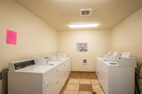 the laundry room is equipped with washers and dryers and has many washing machines
