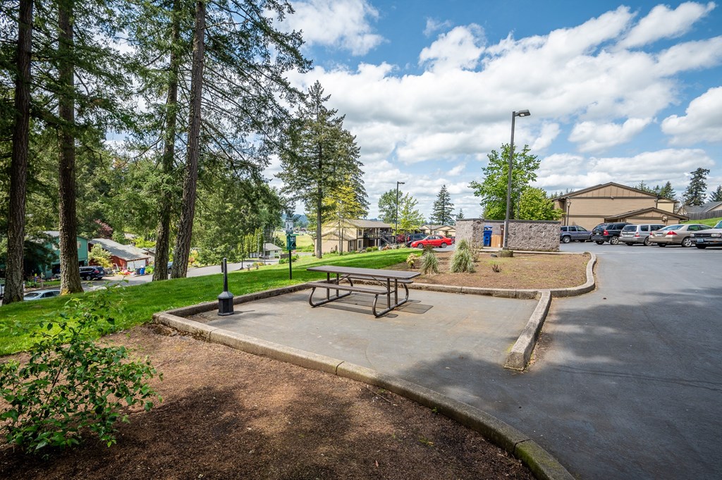 a park with a picnic table and a parking lot
