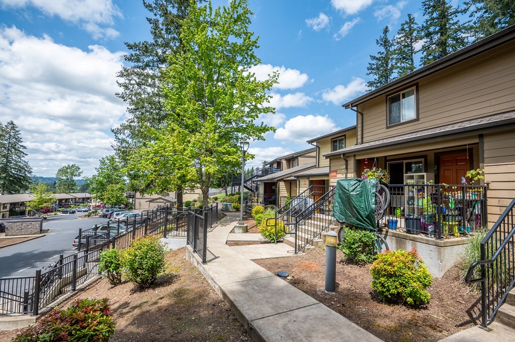 a view of a house with a sidewalk and a parking lot
