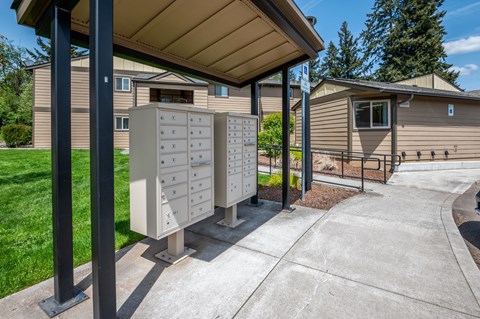 an old mailboxes on a sidewalk in front of a house