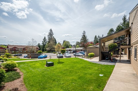 the view of the yard of a house with cars parked in the driveway