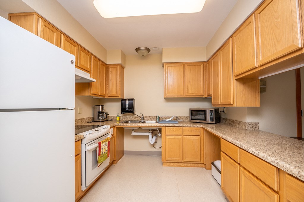 a kitchen with wooden cabinets and appliances and granite counter tops